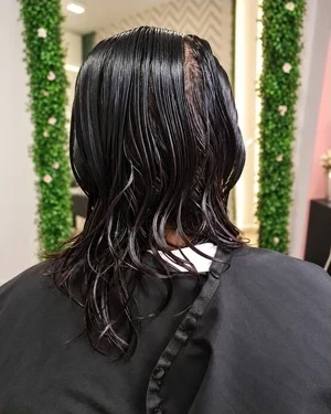 Etapa de processo do caso Alisamento A, com cabelo molhado visto de costas.