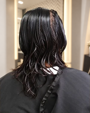 Etapa de processo do caso Alisamento A, com cabelo molhado visto de costas.